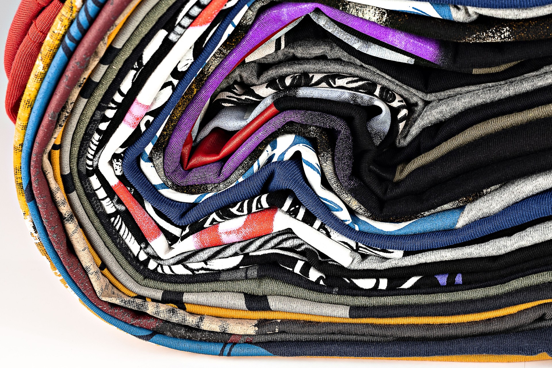 t-shirts with bright prints, printed by silkscreen. serigraphy production. printing images on tshirts in a design studio. selective focus photo